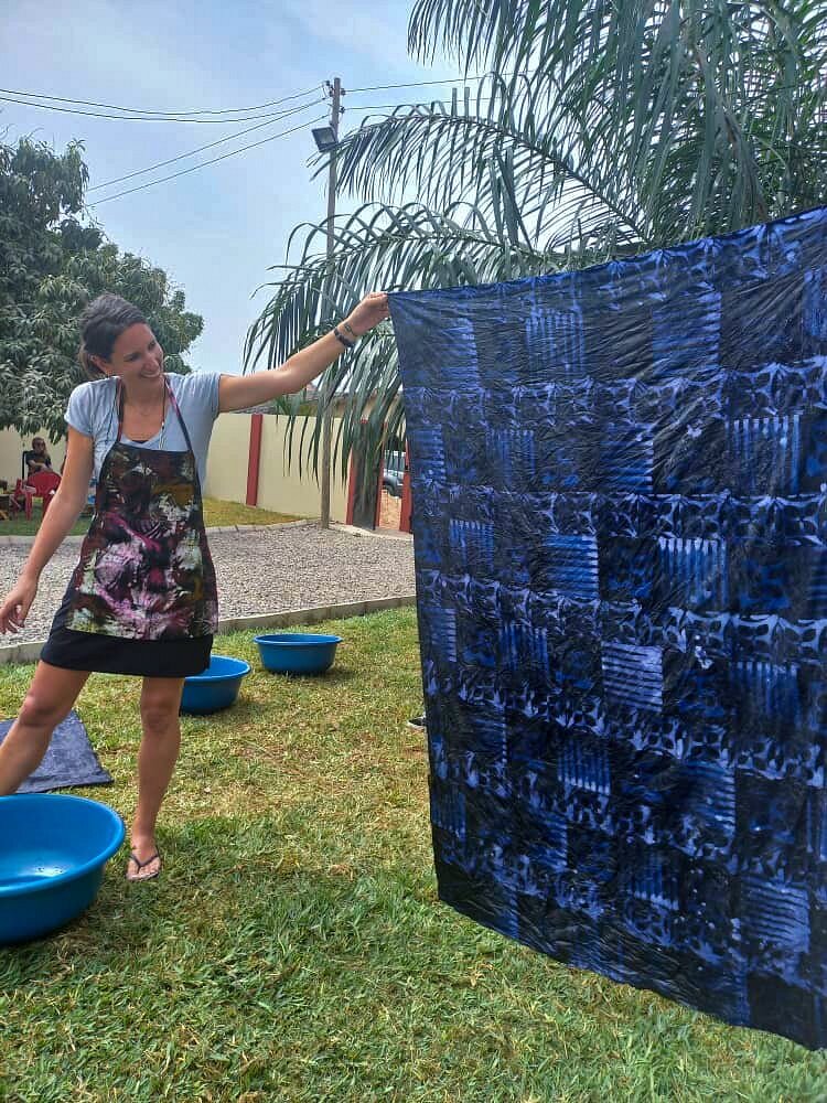 A visitor hanging her dyed cloth to dry in the sun