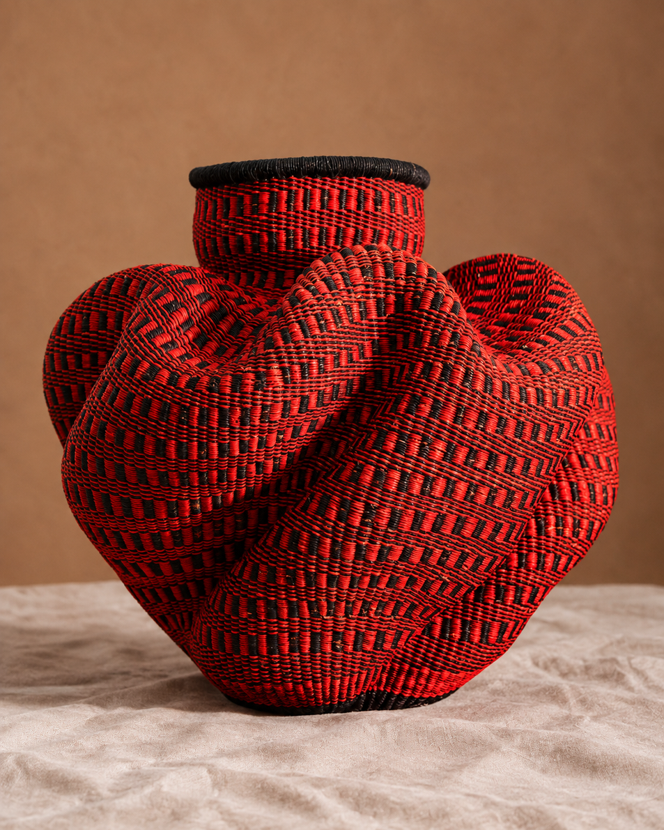 Two large two-tone woven baskets outside a clay building