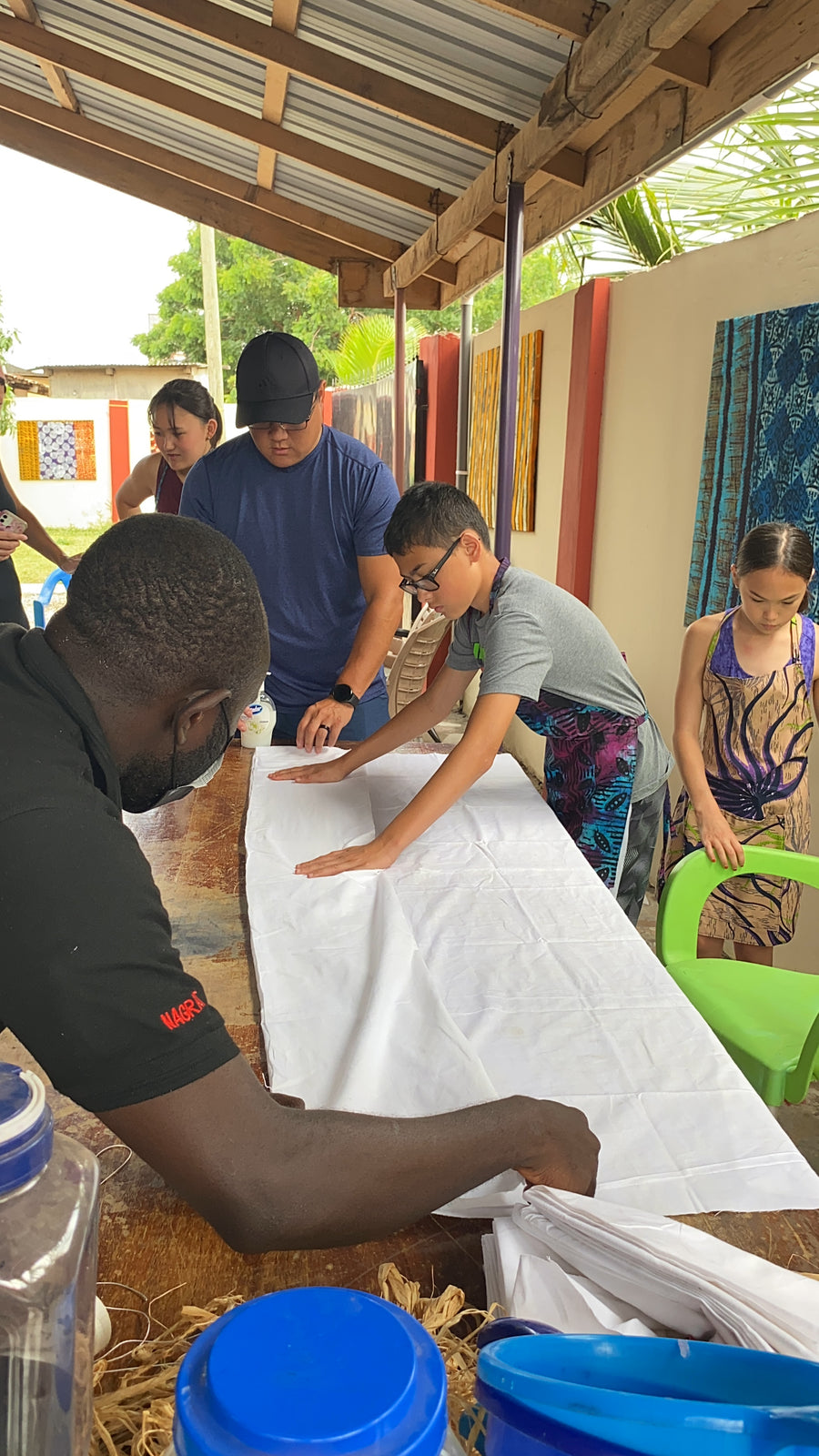 A tutor and visitors preparing cloth at the tables