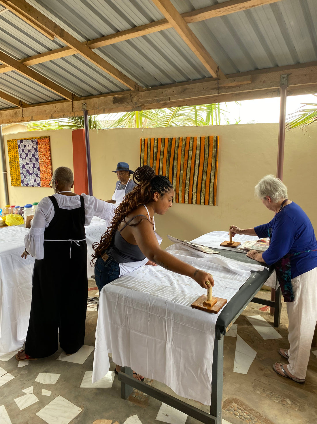 Visitors stamping wax patterns onto cloth at the batik tables