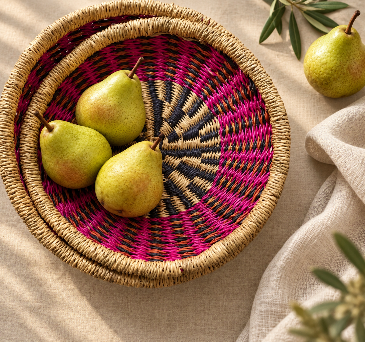 Woven bowl with a pink and black pattern, holding pears